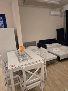 a white table and chairs in a room with beds at Apartment Natasha in Paralia Katerinis