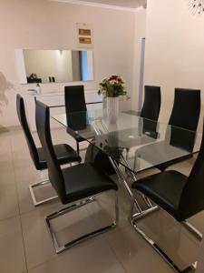 a glass table with black chairs and a vase with flowers at L28 double up apartament in Camama +9 photos