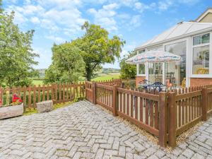 a wooden fence with an umbrella in front of a house at Mavis Cottage in Kington