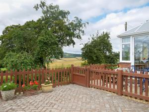 a wooden fence in front of a house at Mavis Cottage in Kington