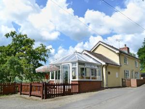 a house with a fence in front of it at Mavis Cottage in Kington +12 photos