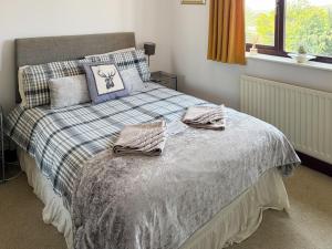 a bedroom with a bed with two towels on it at Combe Cairn in Millom