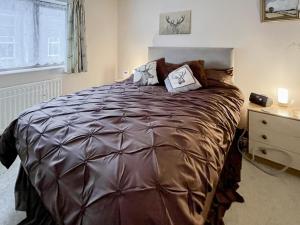 a bedroom with a large bed and a dresser at Combe Cairn in Millom
