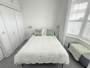 a white bedroom with a large bed with two pillows at Vine - Uk51860 in Ely