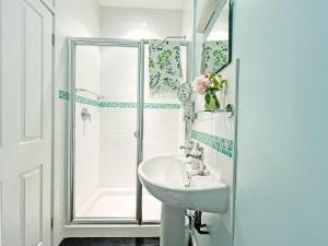 a white bathroom with a sink and a shower at Vine - Uk51860 in Ely