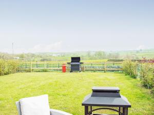 a backyard with a grill and a table in the grass at Acre Hill Cottage in Harrop Fold