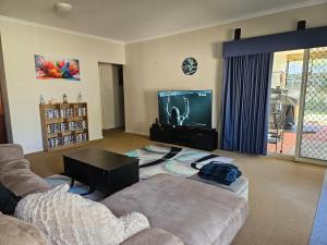 a living room with a couch and a flat screen tv at Hopetoun - footprints in the sand in Hopetoun