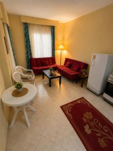 a living room with a red couch and a table at El wadi Pearl Residence in Ain Sokhna