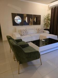 a living room with a white couch and chairs at L28 double up apartament in Camama
