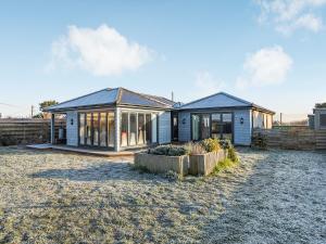 a house with a lot of windows in a yard at Marram Dune Beach House in Brean