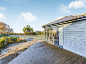 a house with a wooden deck next to a yard at Marram Dune Beach House in Brean