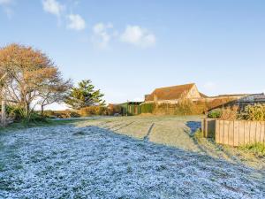 a dirt road with a house in the background at Marram Dune Beach House in Brean +29 photos