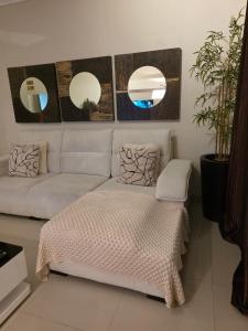 a living room with a couch and two mirrors at L28 double up apartament in Camama