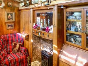 a room with a chair and a cabinet filled with items at Romney Wagon in Hailsham +9 photos