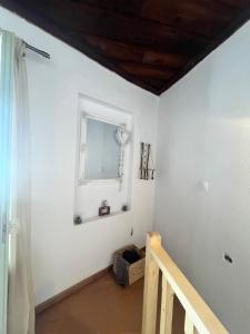 a white room with a mirror and a staircase at Happiness skopelos in Glossa