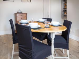 a dining room table with black chairs and a wooden table at Solus Na Madainn in Tain