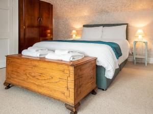 a bedroom with a large bed and a wooden dresser at Solus Na Madainn in Tain
