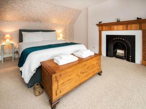 a bedroom with a large bed and a fireplace at Solus Na Madainn in Tain +5 photos