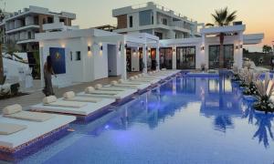 a hotel swimming pool with white buildings in the background at BLUE HORIZON in Saint Amvrosios