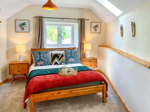 a bedroom with a bed with a red blanket at The Old Posthouse Barn - Uk50191 in Weare