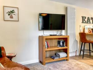 a living room with a television on a shelf at The Old Posthouse Barn - Uk50191 in Weare