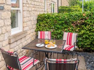 a table and chairs with a plate of food on it at Ridings Cottage in Helmsley
