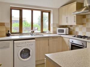 a kitchen with a washing machine and a sink at Coriander - E4323 in Catfield
