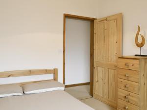 a bedroom with a bed and a wooden dresser at Coriander - E4323 in Catfield +8 photos