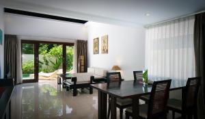 a living room with a table and chairs and a couch at Kebun Villas & Resort in Senggigi
