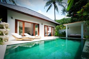 a swimming pool in front of a villa at Kebun Villas & Resort in Senggigi
