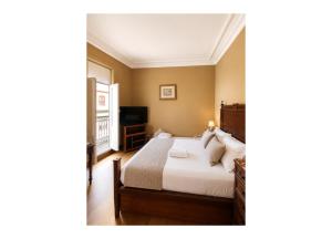 a bedroom with a bed and a television at Casa Quixote, Centro Catedral in Braga
