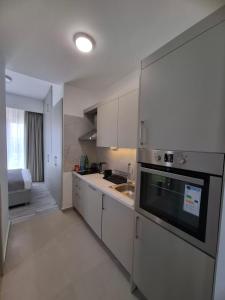 a kitchen with white cabinets and a sink at PMTR Residence in Bar