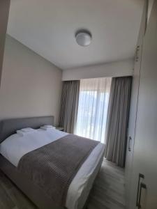 a bedroom with a bed and a large window at PMTR Residence in Bar