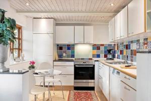 a kitchen with white cabinets and a table with chairs at SJ214-Fredericia-Lillenaes-71 in Fredericia +13 photos