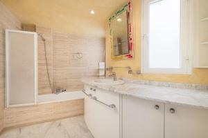 a bathroom with a sink and a tub and a mirror at Port de Pollenca Esmeralda 3 in Port de Pollensa +17 photos