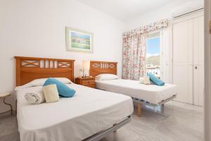 a bedroom with two beds and a window at Port de Pollenca Esmeralda 3 in Port de Pollensa