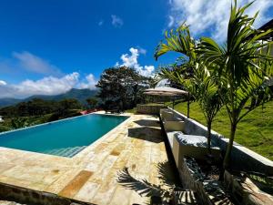 a swimming pool in front of a villa at REFUGIO el CAMPANO in Minca