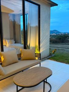 a room with a couch and a large window at Al Badr Villas Resort in Sawdāʼ
