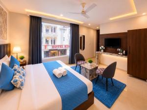a bedroom with a large bed and a living room at Hotel Royal Dot Managed By Sitara Group, Haridwar in Haridwār