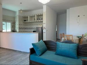 a living room with a couch and a kitchen at Maison pieds dans l'eau in Chebba