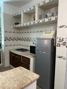 a kitchen with a stove and a refrigerator at Maison pieds dans l'eau in Chebba +3 photos