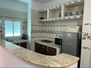 a kitchen with a stove and a refrigerator at Maison pieds dans l'eau in Chebba