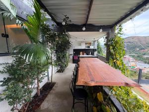 a long wooden table on a patio with plants at Mirante de itaipava in Itaipava