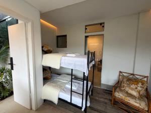 a room with two bunk beds and a chair at Mirante de itaipava in Itaipava +60 photos