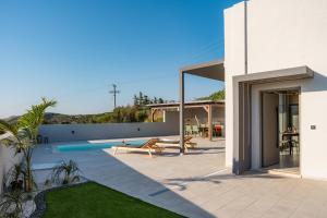 a house with a swimming pool next to a building at Villa Esperia in Áyios Síllas