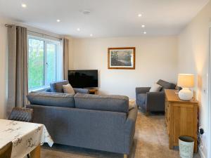 a living room with a couch and a tv at The Narrows in Poolewe
