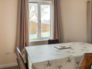 a table in a room with a large window at The Narrows in Poolewe