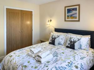 a bedroom with a bed with towels on it at The Narrows in Poolewe +5 photos