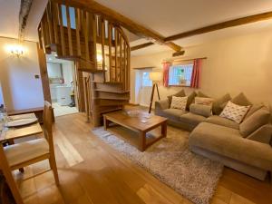 a living room with a couch and a table at The Granary in Little Chart