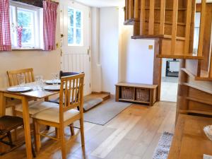 a dining room with a wooden table and chairs at The Granary in Little Chart
